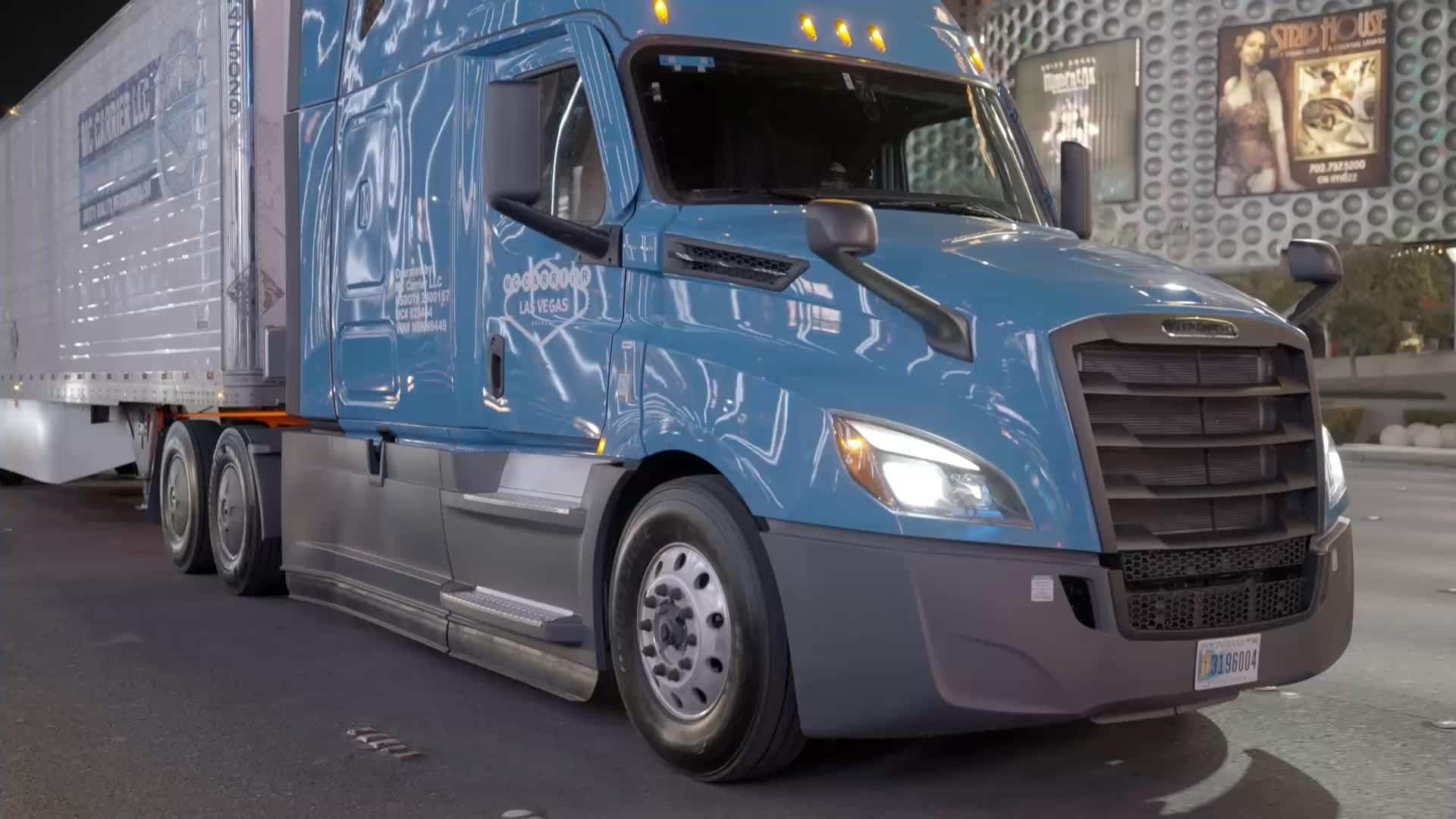An MC Carrier Freightliner with the Las Vegas door livery on the Strip at night